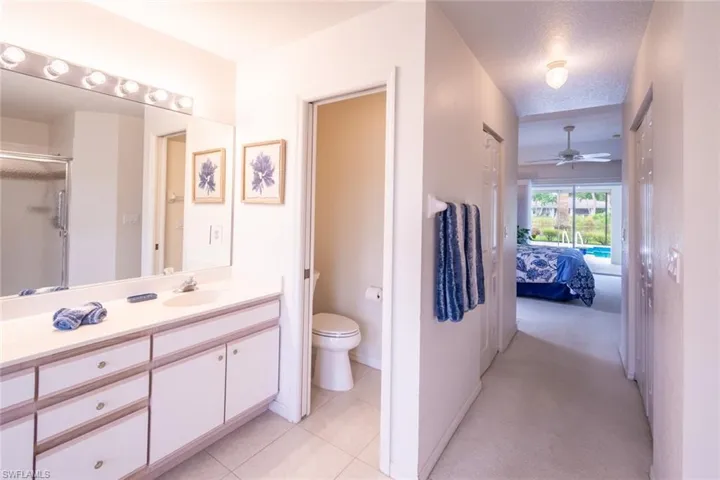 Bathroom featuring tile patterned flooring, a textured ceiling, toilet, vanity, and ceiling fan