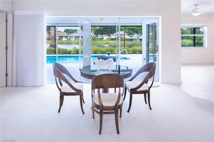 Carpeted dining room featuring ceiling fan