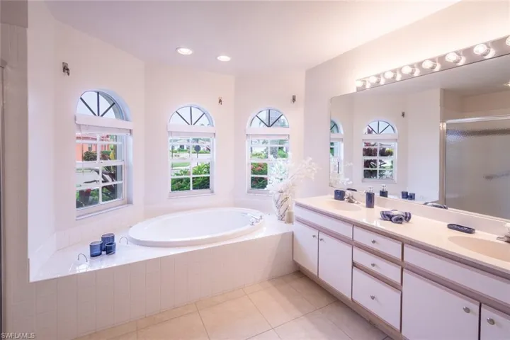 Bathroom featuring shower with separate bathtub, tile patterned flooring, and double sink vanity