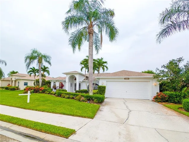 View of front of house with a garage and a front lawn