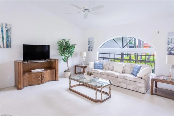 Living room featuring high vaulted ceiling, carpet, and ceiling fan