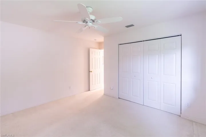 Unfurnished bedroom featuring a closet, carpet floors, and ceiling fan