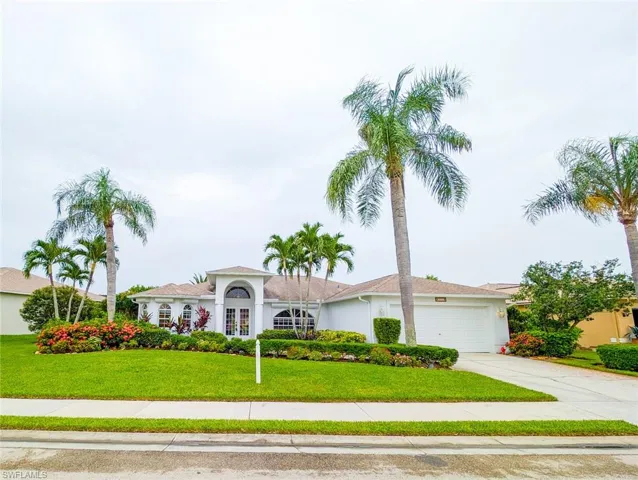 View of front of home with a garage and a front yard