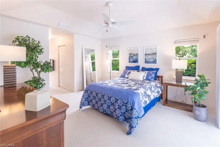 Bedroom featuring multiple windows, carpet, and ceiling fan