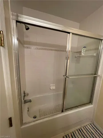 Bathroom with bath / shower combo with glass door