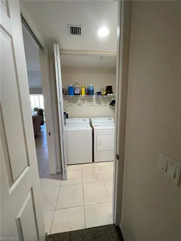 Laundry area featuring separate washer and dryer, washer hookup, and light tile flooring