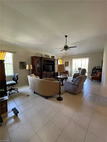 Tiled living room with plenty of natural light and ceiling fan