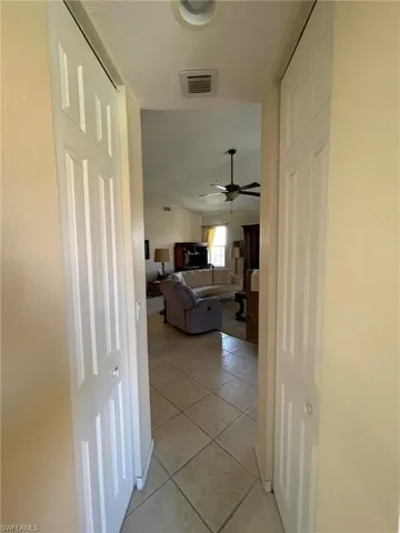 Hallway from kitchen into living room with light tile flooring