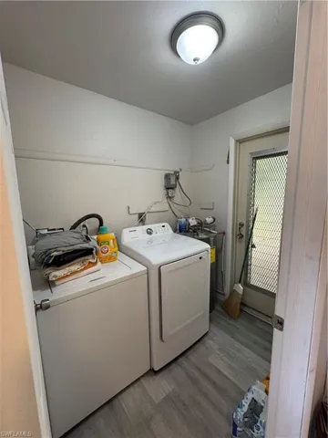 Laundry room with separate washer and dryer and light hardwood / wood-style floors