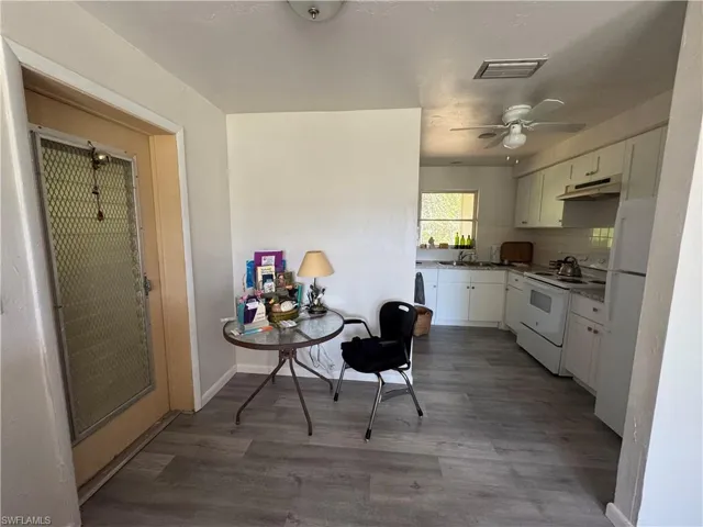 Kitchen featuring white cabinetry, wood-type flooring, sink, and white range with electric stovetop