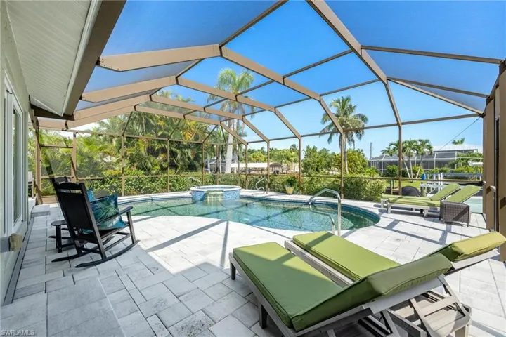 View of swimming pool featuring a lanai, an in ground hot tub, and a patio