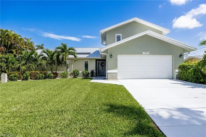 View of front facade with a garage, and a front lawn