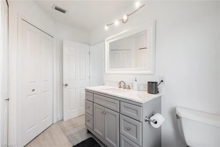 Bathroom featuring wood-type flooring, toilet, and vanity