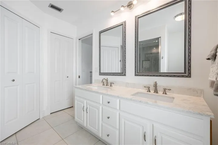 Bathroom with tile patterned flooring, walk in shower, and vanity