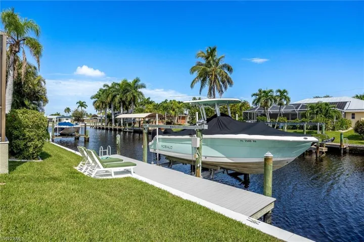View of dock featuring a lawn and a water view