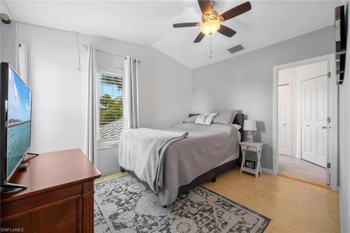 Bedroom featuring ceiling fan, a closet, light hardwood / wood-style floors, and lofted ceiling