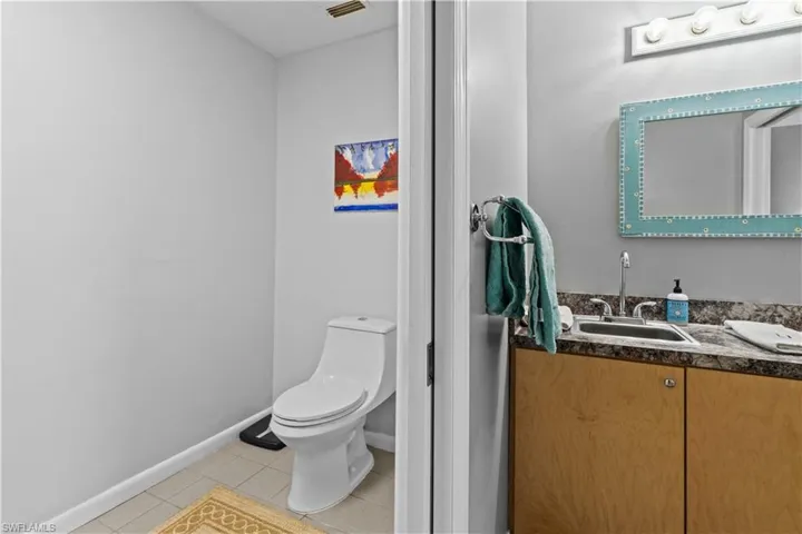 Bathroom with toilet, tile patterned floors, and vanity