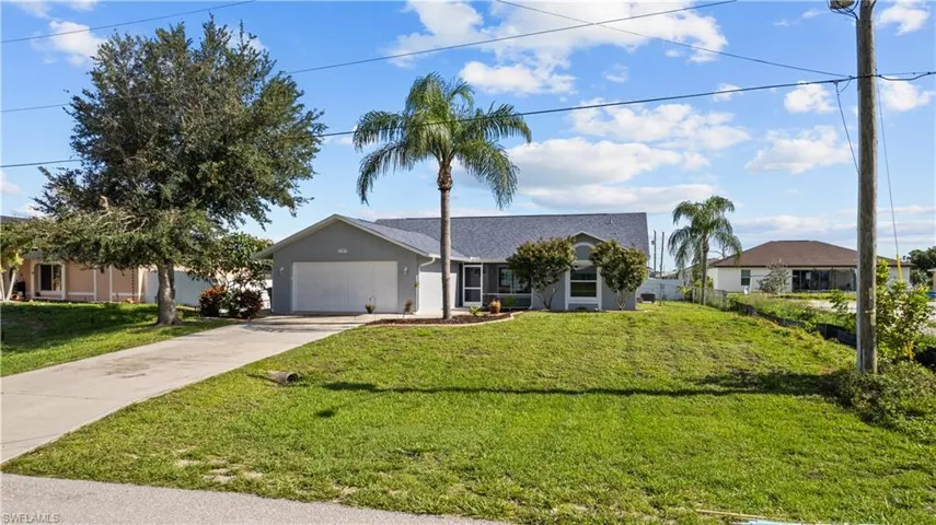 Ranch-style home with a front yard and a garage
