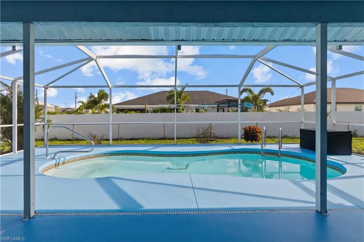 View of swimming pool with glass enclosure and a patio area
