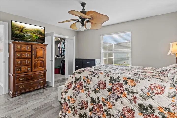 Bedroom featuring a walk in closet, light wood-type flooring, a closet, and ceiling fan