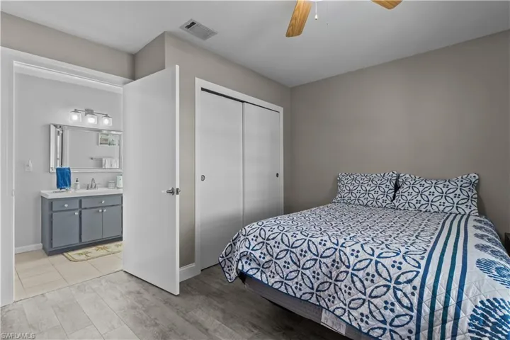 Bedroom with light hardwood / wood-style floors, sink, a closet, and ceiling fan