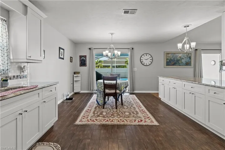 Dining room with a notable chandelier and dark hardwood / wood-style floors