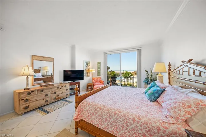Tiled bedroom featuring crown molding and access to outside
