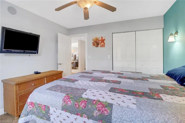 Bedroom with a closet, ceiling fan, and light tile patterned flooring