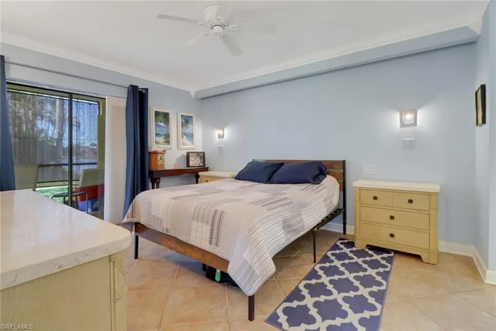 Tiled bedroom featuring access to outside, ceiling fan, and crown molding