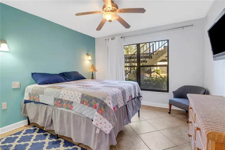Tiled bedroom featuring ceiling fan