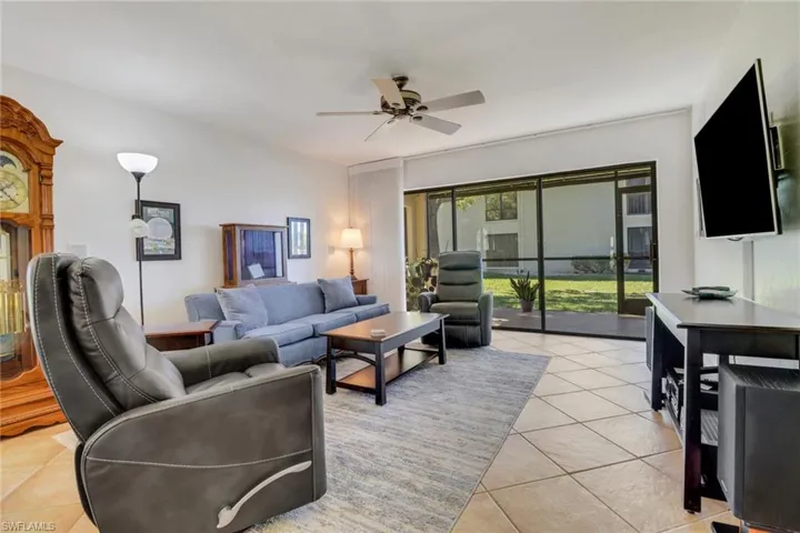 Living room with ceiling fan and light tile patterned floors