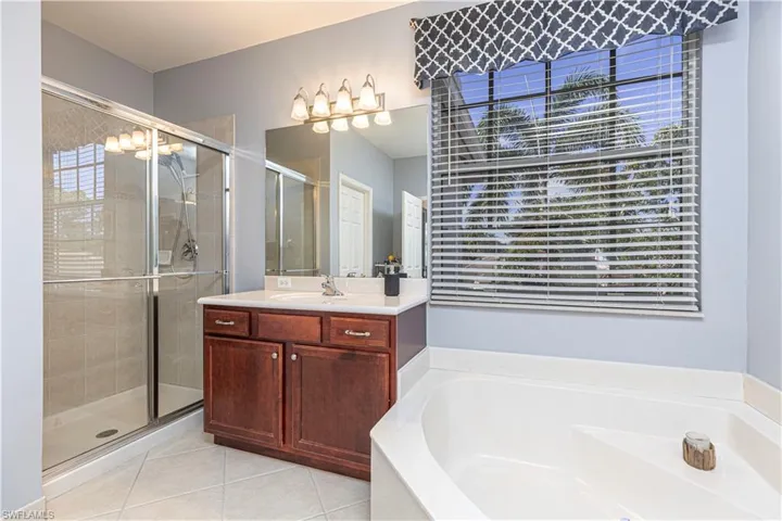 Bathroom featuring tile patterned floors, independent shower and bath, and vanity