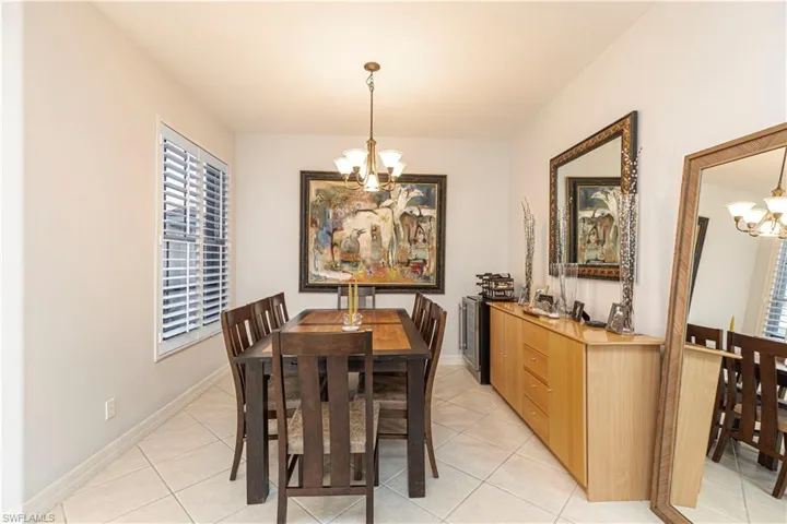 Tiled dining area featuring a notable chandelier