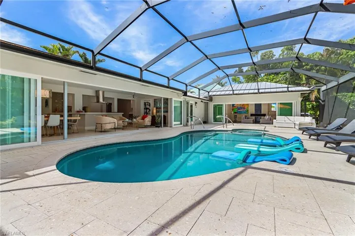 Outdoor pool with an outdoor lounge area, a patio area, a lanai, and a sunroom