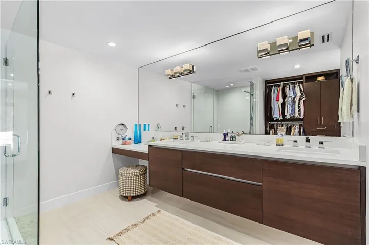 Bathroom with double vanity, light tile patterned floors, a stall shower, a spacious closet, and recessed lighting