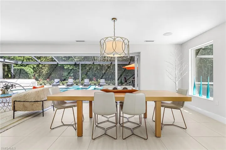 Dining room with a sunroom and light tile patterned flooring