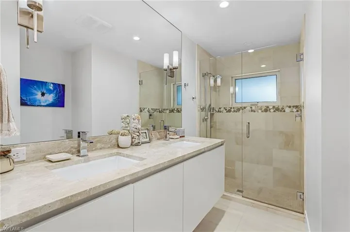Full bathroom featuring double vanity, a stall shower, and recessed lighting