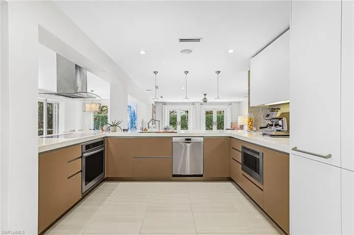 Kitchen with open floor plan, a peninsula, modern cabinets, recessed lighting, and two tone cabinetry