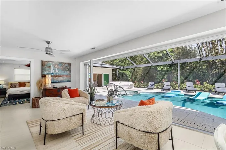 Living area with a sunroom, a ceiling fan, and tile patterned flooring