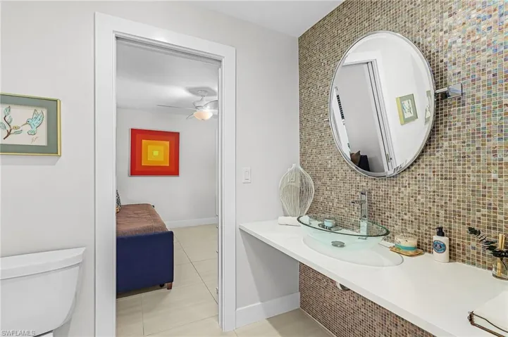 Bathroom featuring vanity, light tile patterned floors, and tasteful backsplash