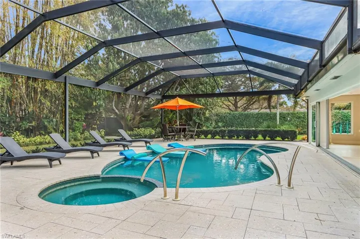 Integrated pool / hot tub featuring a lanai, a patio, and a sunroom