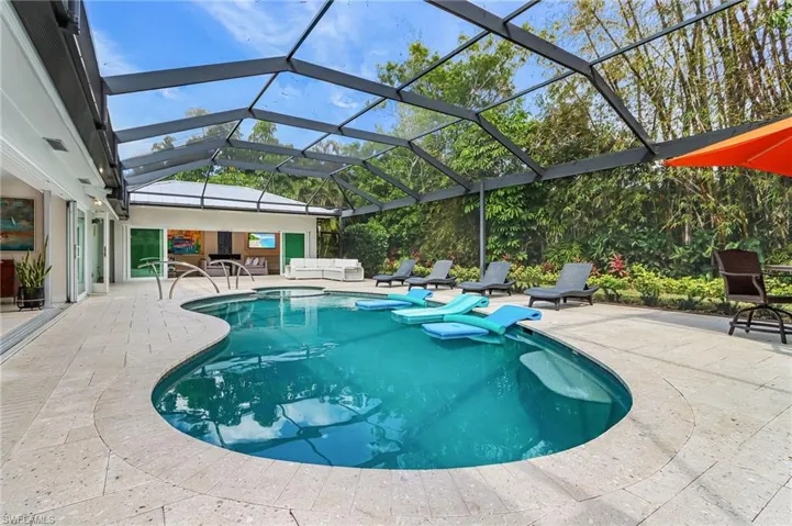 Outdoor pool featuring a patio, glass enclosure, and a sunroom