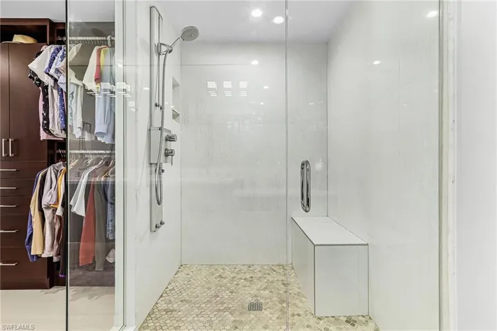 Bathroom featuring a shower stall, a spacious closet, and recessed lighting
