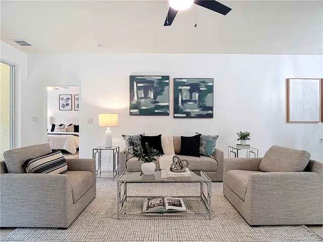 Living area featuring ceiling fan and arched walkways