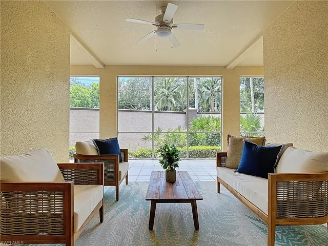 Sunroom with a textured wall, beamed ceiling, healthy amount of natural light, and a textured ceiling