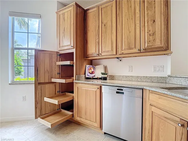 Kitchen featuring stainless steel dishwasher, healthy amount of natural light, and open shelves