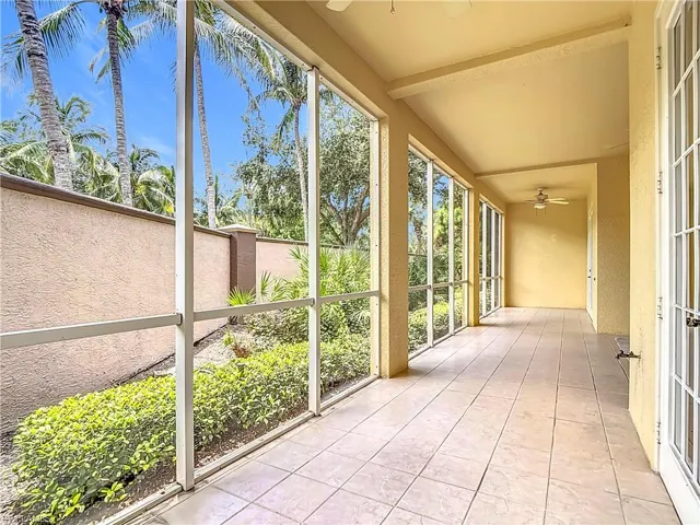 Unfurnished sunroom featuring ceiling fan and beamed ceiling