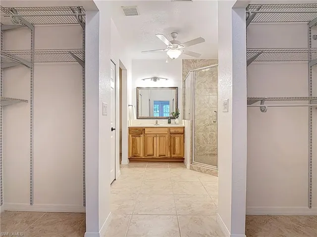 Bathroom with a stall shower, vanity, a ceiling fan, a textured ceiling, and tile patterned flooring