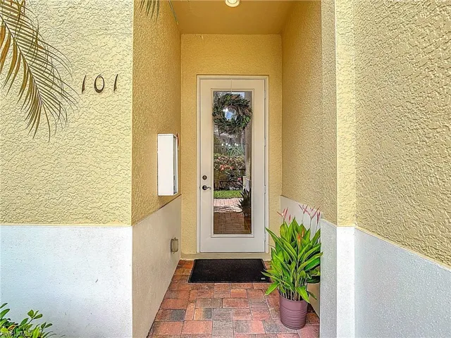 Doorway to property featuring stucco siding
