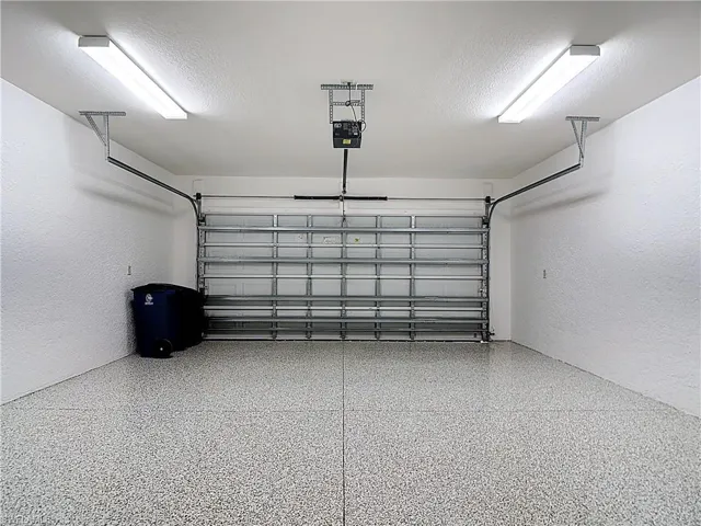 Garage featuring a textured wall and a garage door opener